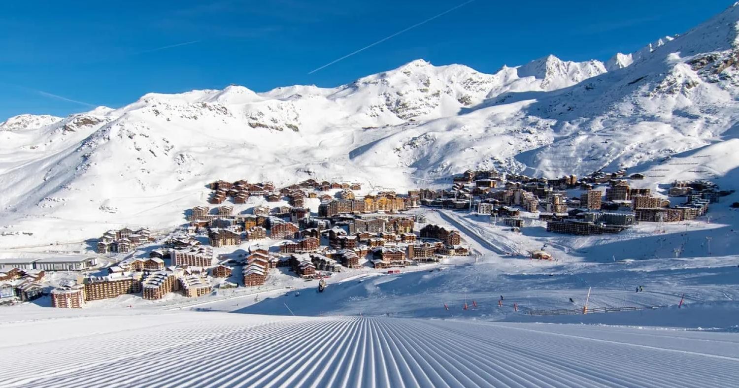 Panoramiczny widok na ośnieżone miasteczko narciarskie Val Thorens we Francji, otoczone majestatycznymi Alpami i idealnie przygotowanymi stokami – zimowy wypoczynek z biurem podróży promoclub.pl