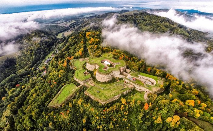Twierdza górska otoczona lasami widziana z lotu ptaka – oferta wycieczek historycznych i krajobrazowych z biurem podróży Promoclub, idealna na aktywne wakacje