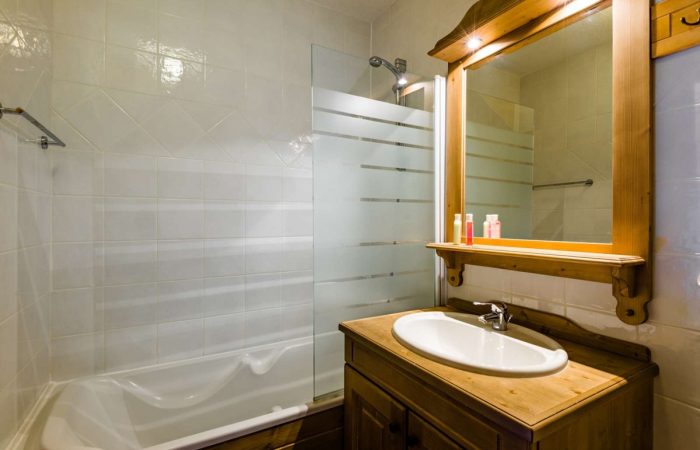 Łazienka w górskim stylu – połączenie naturalnego drewna z jasną ceramiką tworzy ciepły, przytulny klimat idealny po dniu spędzonym na stoku